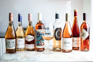 Several bottles of rose wine lined up next to each other.