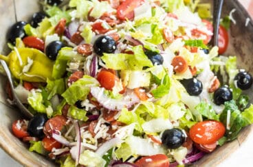 Antipasto salad mixed in a wooden bowl.