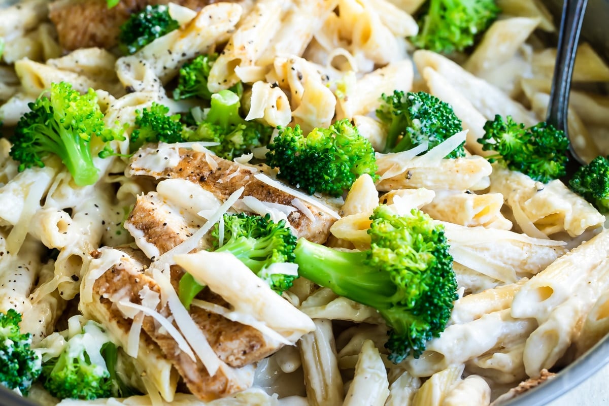 Cajun chicken alfredo with broccoli in a silver skillet.