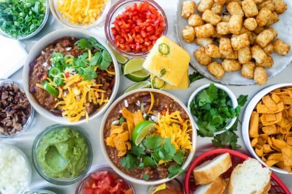 Two bowls of chili on a chili bar.