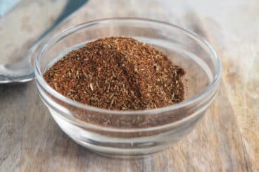 A bowl of homemade chili seasoning on a cutting board.