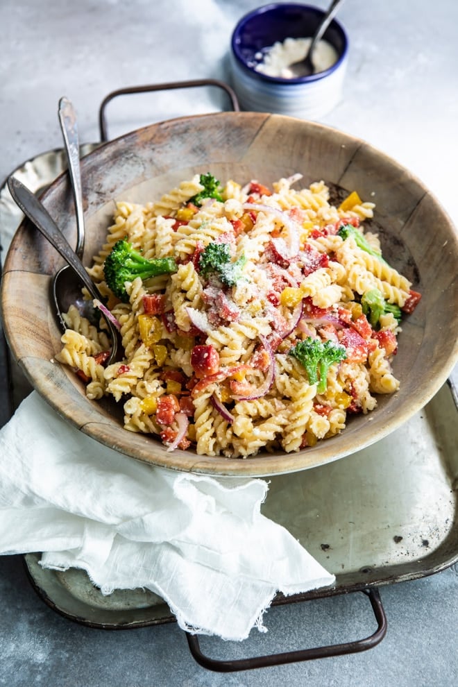 Easy cold pasta salad in a wooden bowl with a serving fork and spoon.