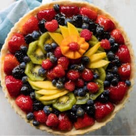 A fresh fruit tart on a counter top.
