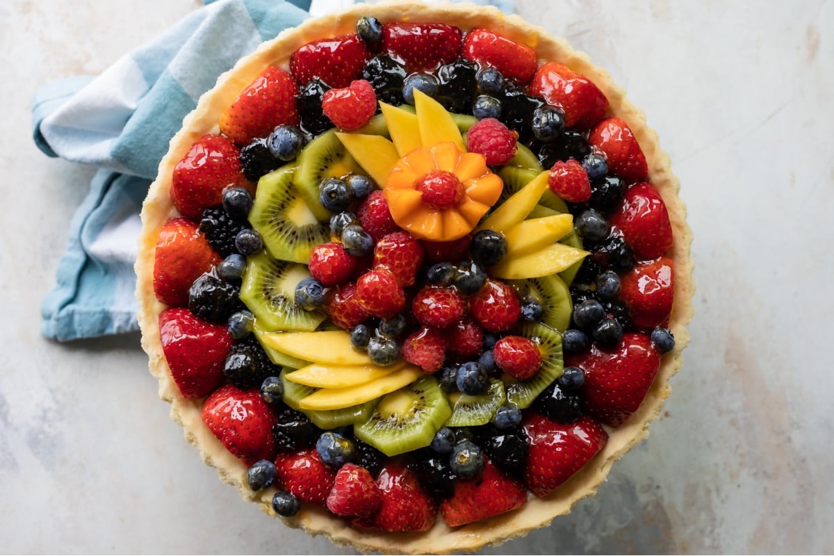 A fresh fruit tart on a counter top.