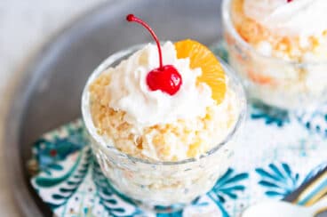 To dishes of frog eye salad with maraschino cherries on top.
