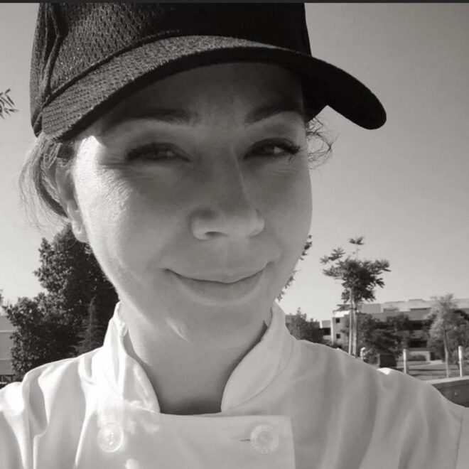 A portrait of Jana wearing a hat.