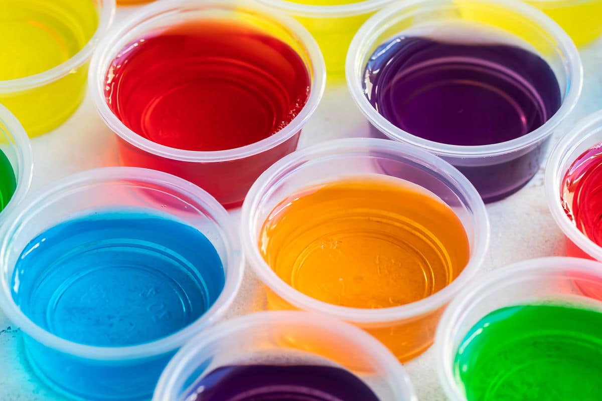 Various colored jello shots in clear portion cups.