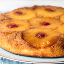 A pineapple upside down cake on a light blue platter.