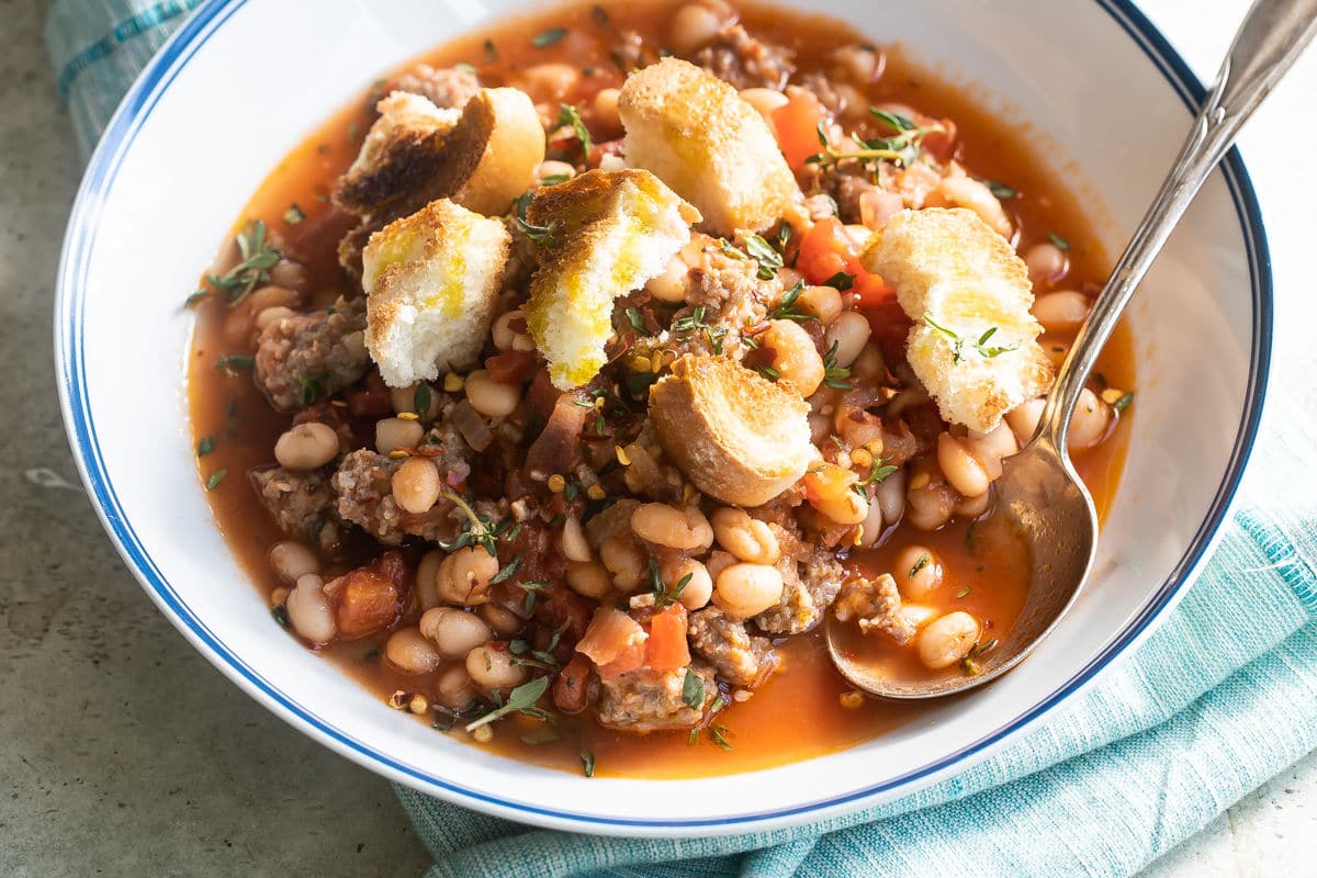 Sausage and bean stew in white bowls.