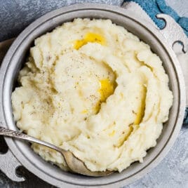 A metal serving dish full of the absolute best mashed potatoes.